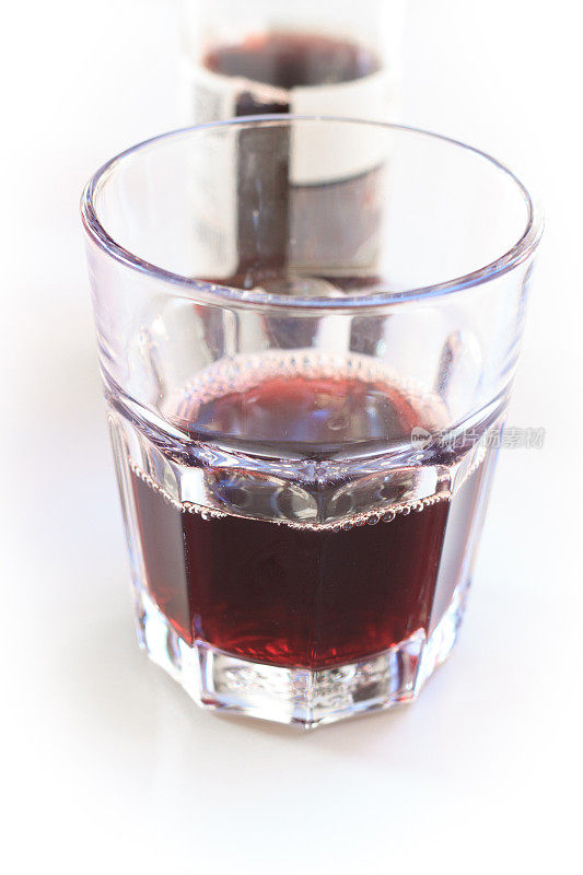 半杯紫色果汁/苏打水，白色背景(特写)